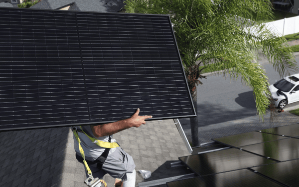 Sun valley solar worker carrying panel on roof-1